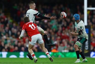 220225 - Wales v Ireland - Guinness Six Nations - Sam Prendergast of Ireland drops the ball whilst under pressure from Ellis Mee of Wales