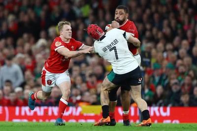 220225 - Wales v Ireland - Guinness Six Nations - Josh van der Flier of Ireland is tackled by Blair Murray and Taulupe Faletau of Wales 