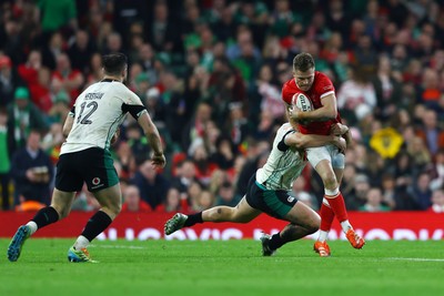 220225 - Wales v Ireland - Guinness Six Nations - Gareth Anscombe of Wales is tackled by James Lowe of Ireland