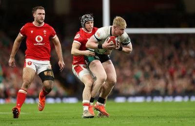 220225 - Wales v Ireland - Guinness 6 Nations Championship - Mack Hansen of Ireland is tackled by Tom Rogers of Wales 