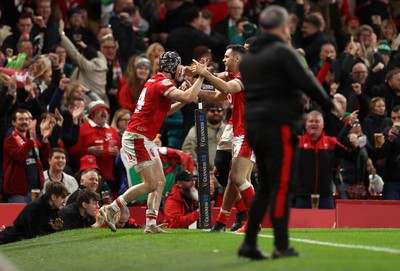 220225 - Wales v Ireland - Guinness 6 Nations Championship - Tom Rogers of Wales celebrates scoring a try with team mates