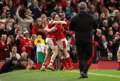 220225 - Wales v Ireland - Guinness 6 Nations Championship - Tom Rogers of Wales celebrates scoring a try with team mates