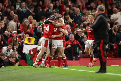 220225 - Wales v Ireland - Guinness 6 Nations Championship - Tom Rogers of Wales celebrates scoring a try with team mates