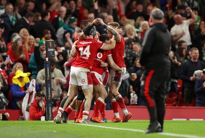 220225 - Wales v Ireland - Guinness 6 Nations Championship - Tom Rogers of Wales celebrates scoring a try with team mates