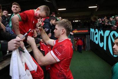 220225 - Wales v Ireland - Guinness 6 Nations Championship - Aaron Wainwright of Wales signs autographs