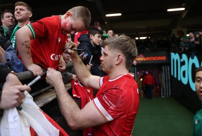 220225 - Wales v Ireland - Guinness 6 Nations Championship - Aaron Wainwright of Wales signs autographs