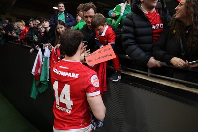 220225 - Wales v Ireland - Guinness 6 Nations Championship - Tom Rogers of Wales signs autographs