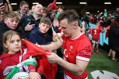 220225 - Wales v Ireland - Guinness 6 Nations Championship - Jarrod Evans of Wales signs autographs