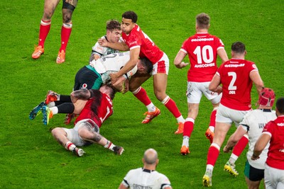 220225 - Wales v Ireland - Guinness Six Nations - Robbie Henshaw of Ireland is tackled by Tommy Reffell of Wales and Ben Thomas of Wales