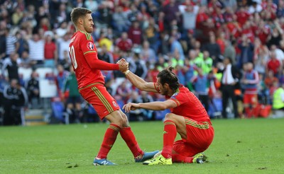 060915 - Wales v Israel, UEFA European Championship 2016 Qualifying match - Gareth Bale of Wales is hauled to his feet by teammate Aaron Ramsey after going close with an attempt at goal
