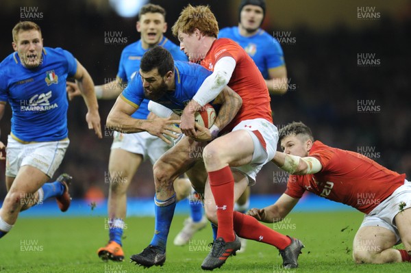 110318 - Wales v Italy - NatWest 6 Nations Championship - Jayden Hayward of Italy is tackled by Rhys Patchell of Wales 