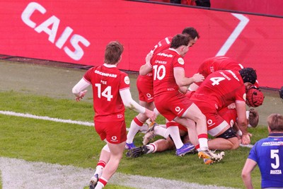 140326 - Wales v Italy - Guinness Six Nations - Wales players jump on Aaron Wainwright of Wales after scoring a try