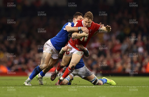 160324 - Wales v Italy - Guinness 6 Nations 2024 - Sam Costelow of Wales is tackled by Paolo Garbisi and Sebastian Negri of Italy 