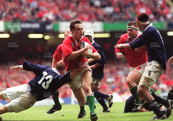 091099 - Wales v Japan - Rugby World Cup - Jason Jones-Hughes bursts through as Japan's captain Andrew McCormick tackles 