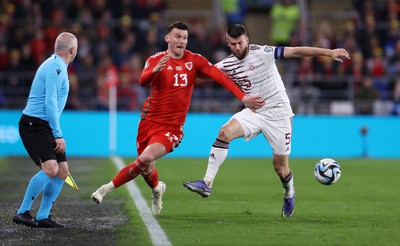 280323 - Wales v Latvia - European Championship Qualifier - Group D - Kieffer Moore of Wales is tackled by Antonijs Cernomordijs of Latvia