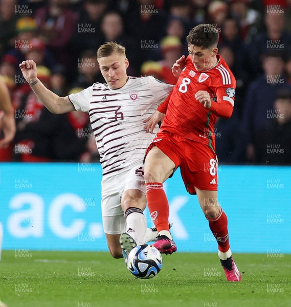 280323 - Wales v Latvia - European Championship Qualifier - Group D - Kristers Tobers of Latvia is tackled by Harry Wilson of Wales