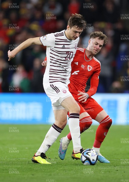 280323 - Wales v Latvia - European Championship Qualifier - Group D - Roberts Uldrkis of Latvia is tackled by Joe Rodon of Wales