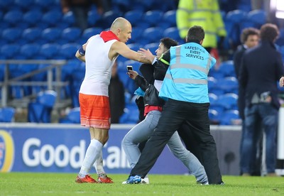 131115 - Wales v Netherlands, Vauxhall International Friendly - A fan battles with stewards as he gets to Arjen Robben of Netherlands at the end of the match