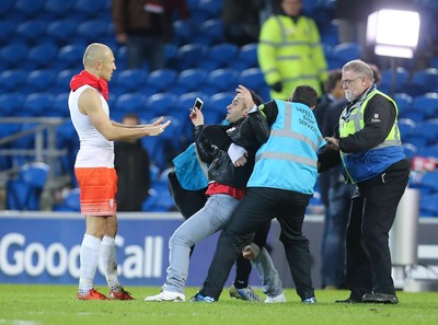 131115 - Wales v Netherlands, Vauxhall International Friendly - A fan battles with stewards as he gets to Arjen Robben of Netherlands at the end of the match