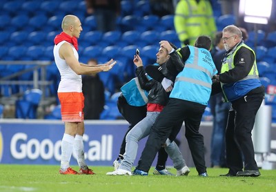 131115 - Wales v Netherlands, Vauxhall International Friendly - A fan battles with stewards as he gets to Arjen Robben of Netherlands at the end of the match