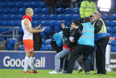 131115 - Wales v Netherlands, Vauxhall International Friendly - A fan battles with stewards as he gets to Arjen Robben of Netherlands at the end of the match