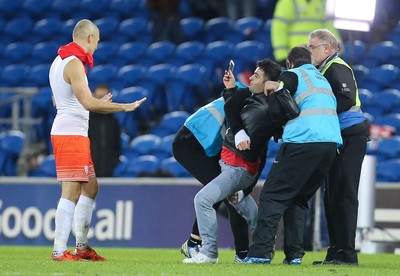131115 - Wales v Netherlands, Vauxhall International Friendly - A fan battles with stewards as he gets to Arjen Robben of Netherlands at the end of the match