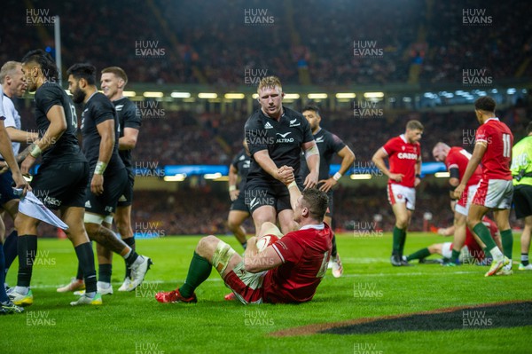 051122 - Wales v New Zealand - Autumn Nations Series - Will Rowlands of Wales is helped to his feet by Fletcher Newell of New Zealand 