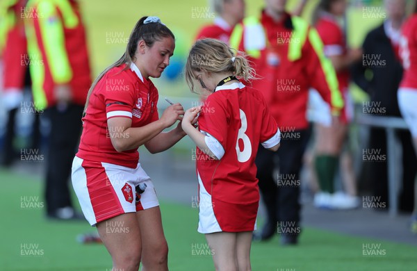 161022 - Wales v New Zealand, Women’s Rugby World Cup 2021, Pool A - Kayleigh Powell of Wales signs an autograph for one young fan at the end of the match