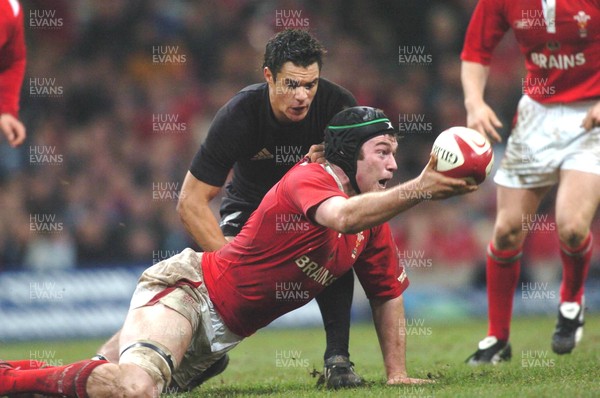 20-11-04. Wales v New Zealand   Wales' Michael Owen offloads ball as Daniel Carter tackles.  