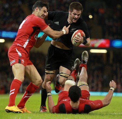 221114 - Wales v New Zealand - Dove Men Series 2014 - Richie McCaw of New Zealand is dragged down by Mike Phillips and Taulupe Faletau of Wales 