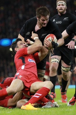 221114 - Wales v New Zealand - Dove Men Series 2014 - Richie McCaw of New Zealand is dragged down by Mike Phillips and Taulupe Faletau of Wales 