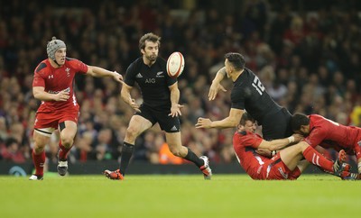 221114 -  Wales v New Zealand, Dove Men Series 2014, Cardiff - Sonny Bill Williams of New Zealand offloads to Conrad Smith of New Zealand as he's tackled 