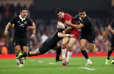 221125 - Wales v New Zealand All Blacks - Quilter Nations Series - Louis Rees-Zammit of Wales is tackled by Will Jordan and Rieko Ioane of New Zealand 