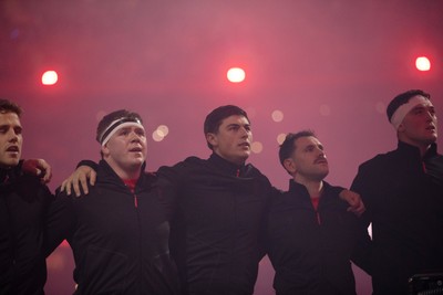 221125 - Wales v New Zealand All Blacks - Quilter Nations Series - Brodie Coghlan, Louis Rees-Zammit and Tomos Williams of Wales during the anthem