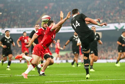 221125 - Wales v New Zealand - Quilter Nations Series - Will Jordan of New Zealand kicks the ball under pressure from Tomos Williams of Wales