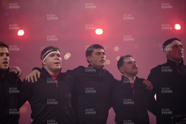 221125 - Wales v New Zealand All Blacks - Quilter Nations Series - Brodie Coghlan, Louis Rees-Zammit and Tomos Williams of Wales during the anthem