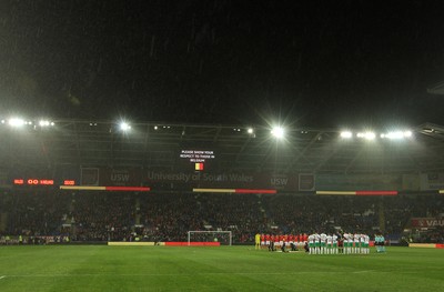 240316 - Vauxhall International Friendly - Wales v Northern Ireland -Players of Wales and Northern Ireland pay their respects