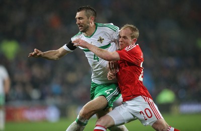 240316 - Wales v Northern Ireland, International Friendly - Jonathan Williams of Wales and Gareth McAuley of Northern Ireland tangle as the compete for the ball