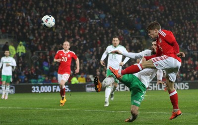 240316 - Wales v Northern Ireland, International Friendly - Lloyd Isgrove of Walesgets a shot at goal as Conor McLaughlin of Northern Ireland challenges