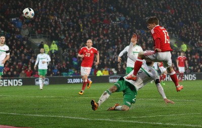 240316 - Wales v Northern Ireland, International Friendly - Lloyd Isgrove of Walesgets a shot at goal as Conor McLaughlin of Northern Ireland challenges
