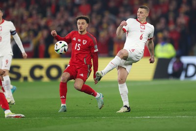 260324 - Wales v Poland, Euro 2024 qualifying Play-off Final - Jakub Piotrowski of Poland plays the ball past Ethan Ampadu of Wales