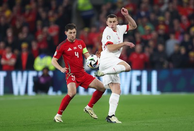 260324 - Wales v Poland, Euro 2024 qualifying Play-off Final - Jakub Piotrowski of Poland plays the ball past Ben Davies of Wales