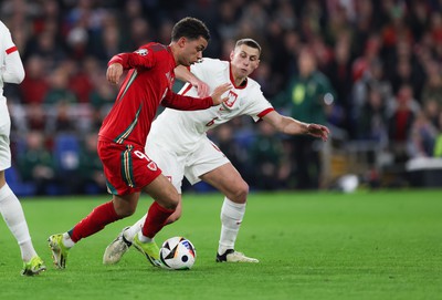 260324 - Wales v Poland, Euro 2024 qualifying Play-off Final - Brennan Johnson of Wales is challenged by Jakub Piotrowski of Poland