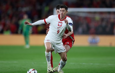 260324 - Wales v Poland, Euro 2024 qualifying Play-off Final - Robert Lewandowski of Poland holds off Ben Davies of Wales