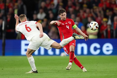 260324 - Wales v Poland, Euro 2024 qualifying Play-off Final - Ben Davies of Wales plays the ball past Jakub Piotrowski of Poland