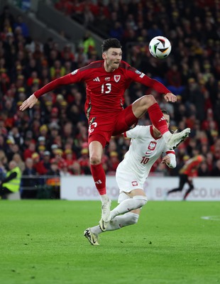 260324 - Wales v Poland, Euro 2024 qualifying Play-off Final - Kieffer Moore of Wales wins the ball from Piotr Zielinski of Poland