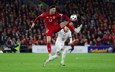 260324 - Wales v Poland, Euro 2024 qualifying Play-off Final - Kieffer Moore of Wales wins the ball from Piotr Zielinski of Poland