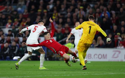 260324 - Wales v Poland, Euro 2024 qualifying Play-off Final - Harry Wilson of Wales challenges Wojciech Szczesny of Poland