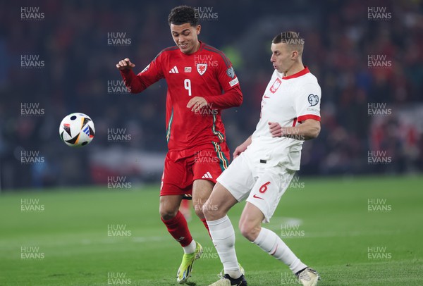 260324 - Wales v Poland, Euro 2024 qualifying Play-off Final - Brennan Johnson of Wales and Jakub Piotrowski of Poland compete for the ball
