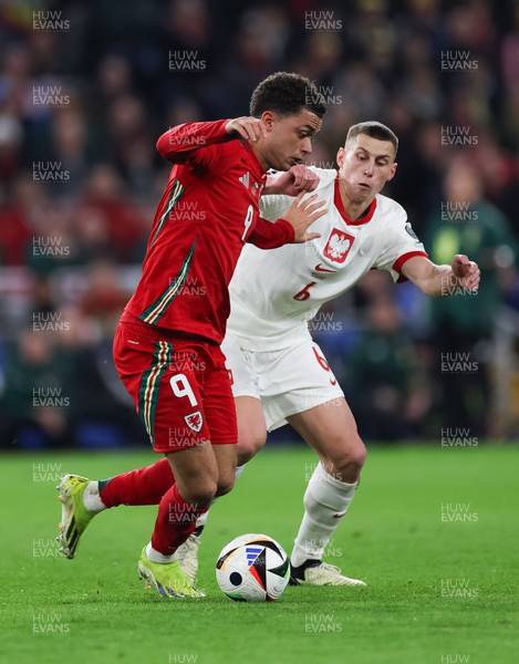260324 - Wales v Poland, Euro 2024 qualifying Play-off Final - Brennan Johnson of Wales is challenged by Jakub Piotrowski of Poland